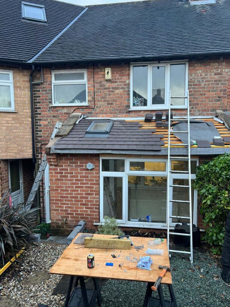 This is a photo of a roof extension that is having new roof tiles installed. This is a photo taken from the roof ridge looking down a tiled pitched roof on to a flat roof. Works carried out by Arundel Roofing Repairs