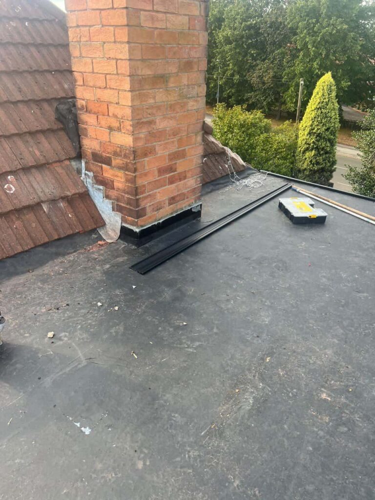 This is a photo of a flat roof which has just been repaired, there is also a chimney stack and some leadwork has also been dressed. Works carried out by Arundel Roofing Repairs